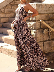 Woman wearing a leopard print dress standing on stone steps.